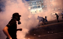 EU hails Greek austerity plan as protesters, police clash in Athens
