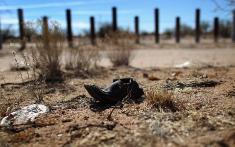 A discarded shoe lies along the porous U.S.-Mexico border fence which stretches through the Sonoran Desert. 