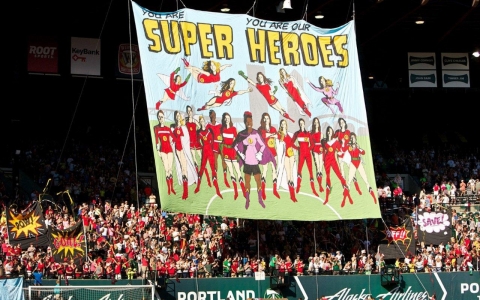 Fans of the Portland Thorns women's soccer team unfurl a banner honoring the team.