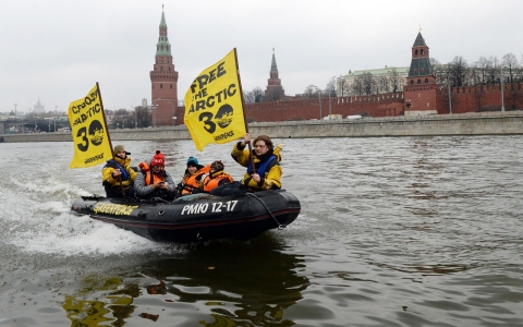 Greenpeace activists hold flags reading 'Free the Arctic 30' as they go past the Kremlin by boat to protest the detention of the 'Arctic 30'