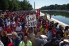 Thousands of people line the reflecting pool near the Lincoln Memorial while listening to speakers 