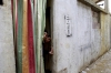 <b>Lebanon, 2012.</b> Palestinian boys from the Syrian refugee camp of Yarmuk peer through the entrance of their temporary home at the Shatila refugee camp in Beirut. Many Palestinians who had lived as refugees in Syria have been forced to relocate once again as the civil war in that country has intensified. 