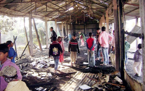 People look at burnt textbooks after a primary school which was supposed to be used as a polling booth was set on fire, in Feni, Bangladesh on Saturday.