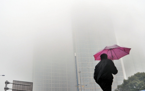 A man holding umbrella walks in the haze on February 24, 2014, in Changsha, Hunan Province of China. 