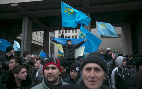 Crimean Tatars hold their flag during rallies near the Crimean parliament building in Simferopo, Ukraine on Feb. 26, 2014.