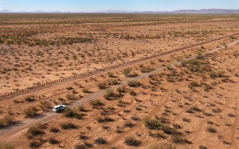 U.S. Border Patrol agents drive along the U.S.-Mexico border fence in Arizona.