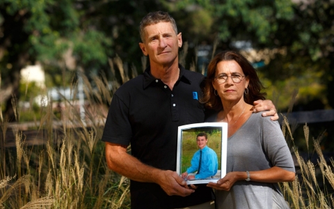 Scott Starkey and Julia Starkey hold a photograph of their son, Carson, who died of alcohol poisoning while pledging SAE at California Polytechnic State University.