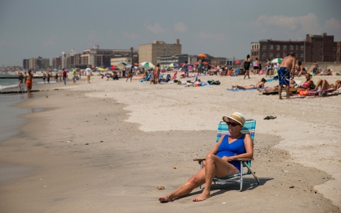 A woman sunbathes at Rockaway Beach during a heat wave on July 17, 2013 in the Rockaway Beach neighborhood of the Queens borough of New York City. 