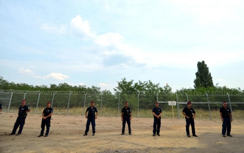 Soldiers of the Hungarian Army's technical unit in front of the first completed elements of the 150 meter-long metal fence at the Hungarian-Serbian border on July 18, 2015.