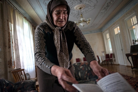 Badi, the leader of the female Sufi group, shows off pamphlets from trips and tours the group completed.