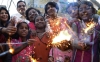 Children and aid workers pose with fireworks on the eve of Diwali in Amritsar, India on Nov. 2, 2013.