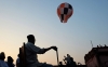 A sky lantern floats past family members gathered on a roof on the eve of Diwali in Kolkata on Nov. 2, 2013.