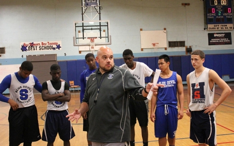 Coach Anthony Nicodemo, middle, goes over the goals of the first practice with the men's basketball team at Saunders High School in Yonkers, N.Y., earlier this month.