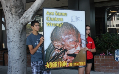 Two Survivors campers hold one of the many anti-abortion signs outside Cedars-Sinai.