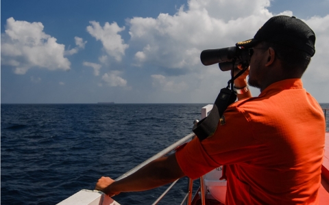 A member of the Indonesian National Search and Rescue Agency scans the seas off northern Sumatra island on March 12, 2014.