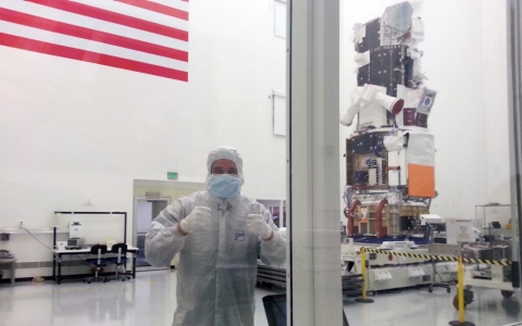"TechKnow" contributor Phil Torres stands inside Ball Aerospace's satellite production facility.