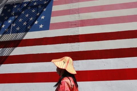 A woman walks by an American flag mural in Chinatown on June 19, 2012 in San Francisco, California (Getty/Justin Sullivan).