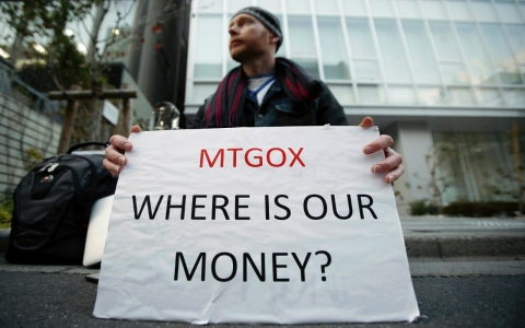 Kolin Burges, a Mt. Gox customer, holds a placard while protesting outside a building housing the headquarters of Mt. Gox in Tokyo, Japan.